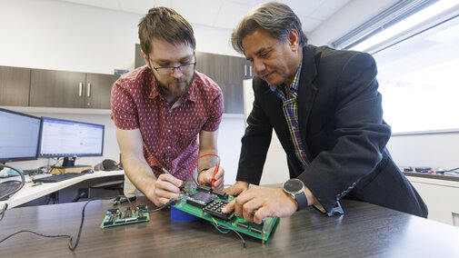 two people working with a pcb