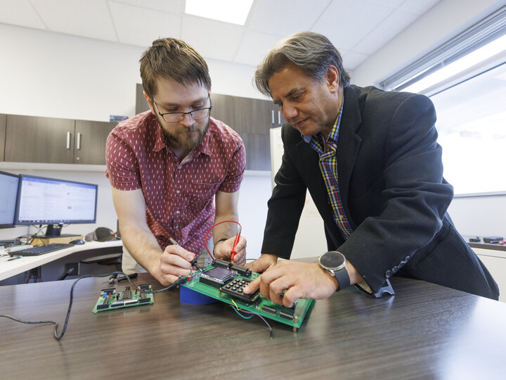 two people working with a pcb
